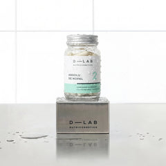 Absolu de Nopal D-LAB Nutricosmetics, cure 1 mois : flacon en verre de gélules posé sur un socle inox brossé, fond carrelage blanc