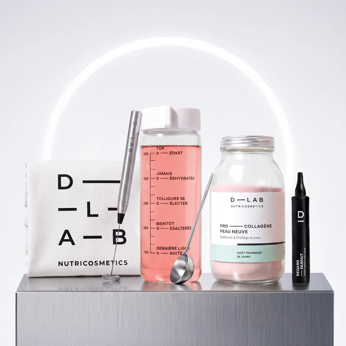 Routine Découverte Peau D-LAB : flacon Boisson Peau Neuve framboise, shot Regard Parfait contour des yeux, gourde en verre graduée, mousseur à lait, cuillère doseuse et tote-bag coton