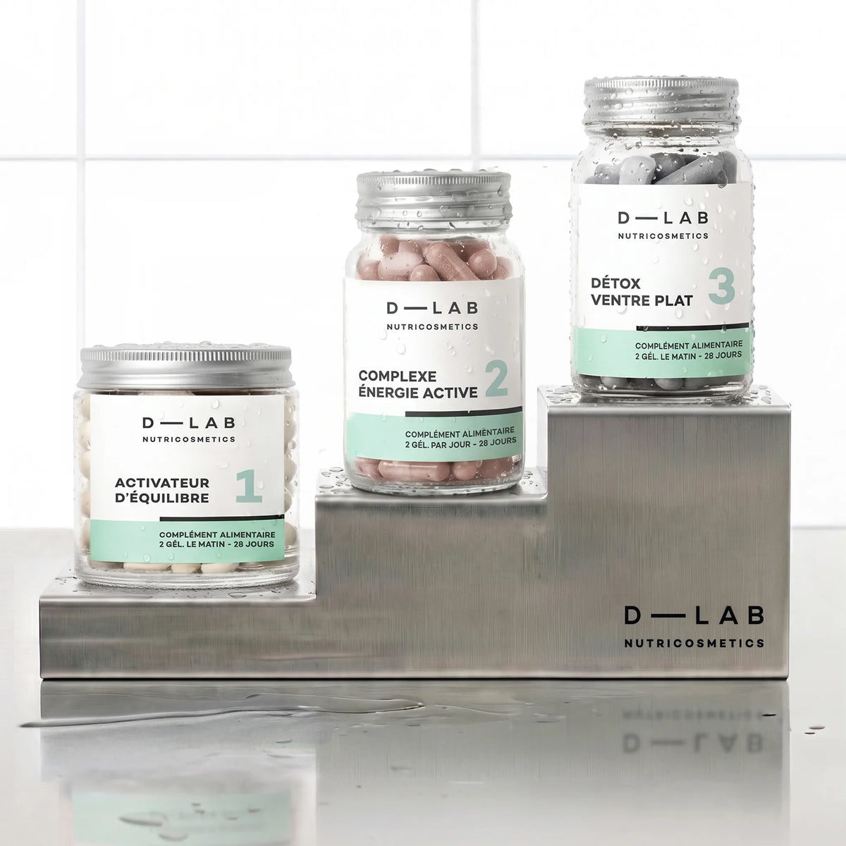Routine Ventre Plat D-LAB cure 1 mois, les trois pots Activateur d'Équilibre, Complexe Énergie Active et Détox Ventre Plat en escalier sur socles inox